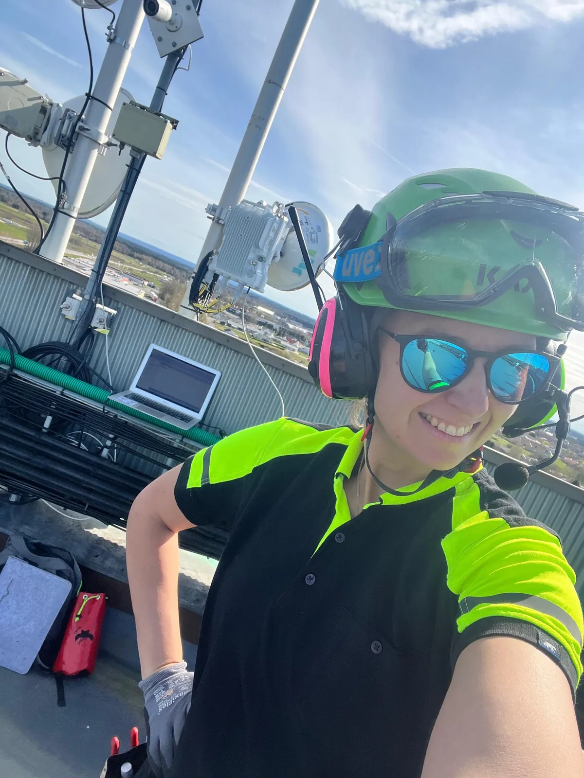 Technician commissioning a rooftop microwave unit with a laptop